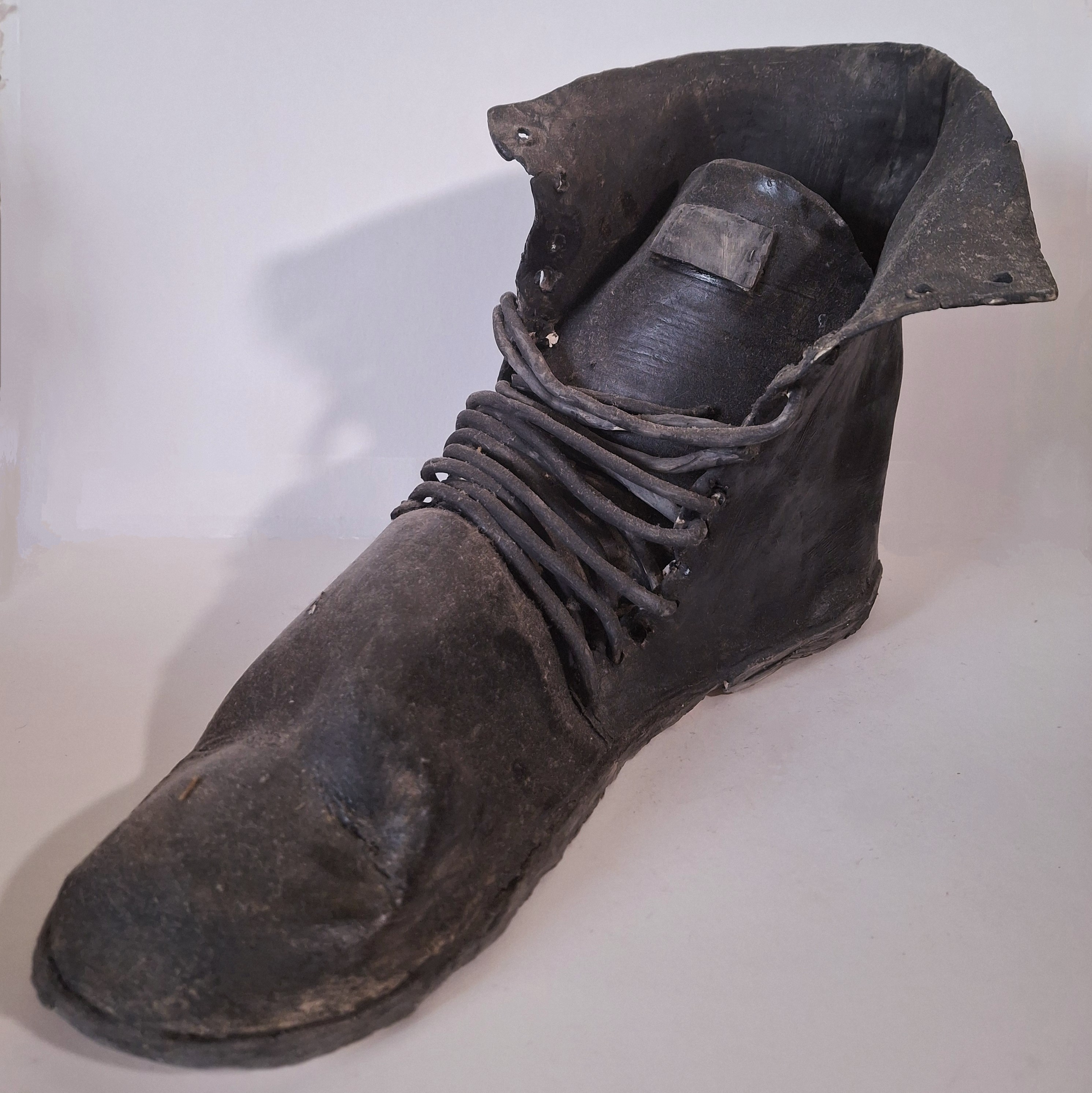 A ceramic sculpture of an old boot.