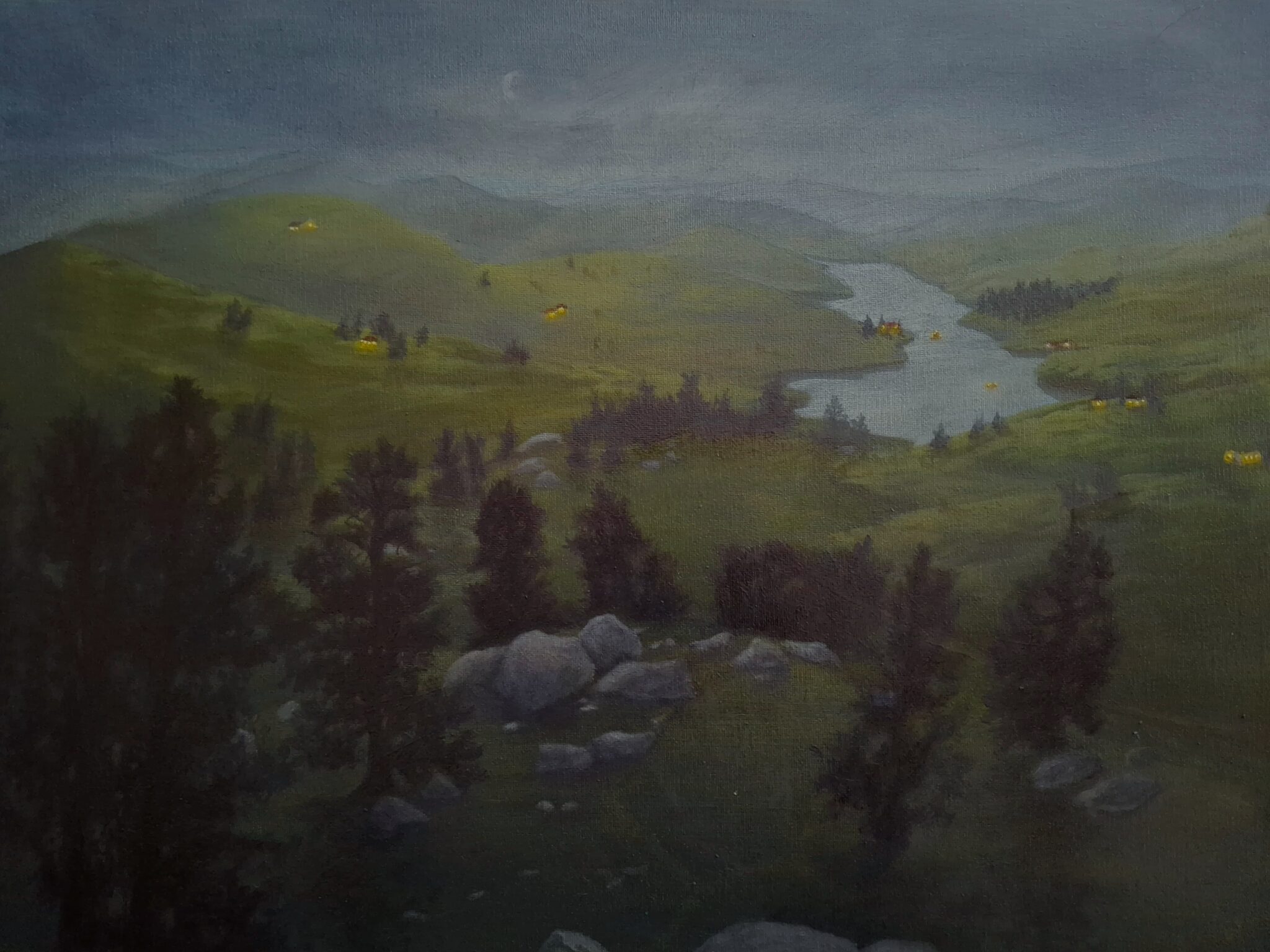 A night view of a valley with distant houses.