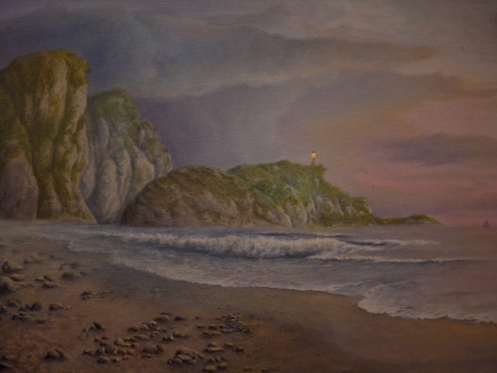 A beach scene at sunset with a lighthouse in the distance.