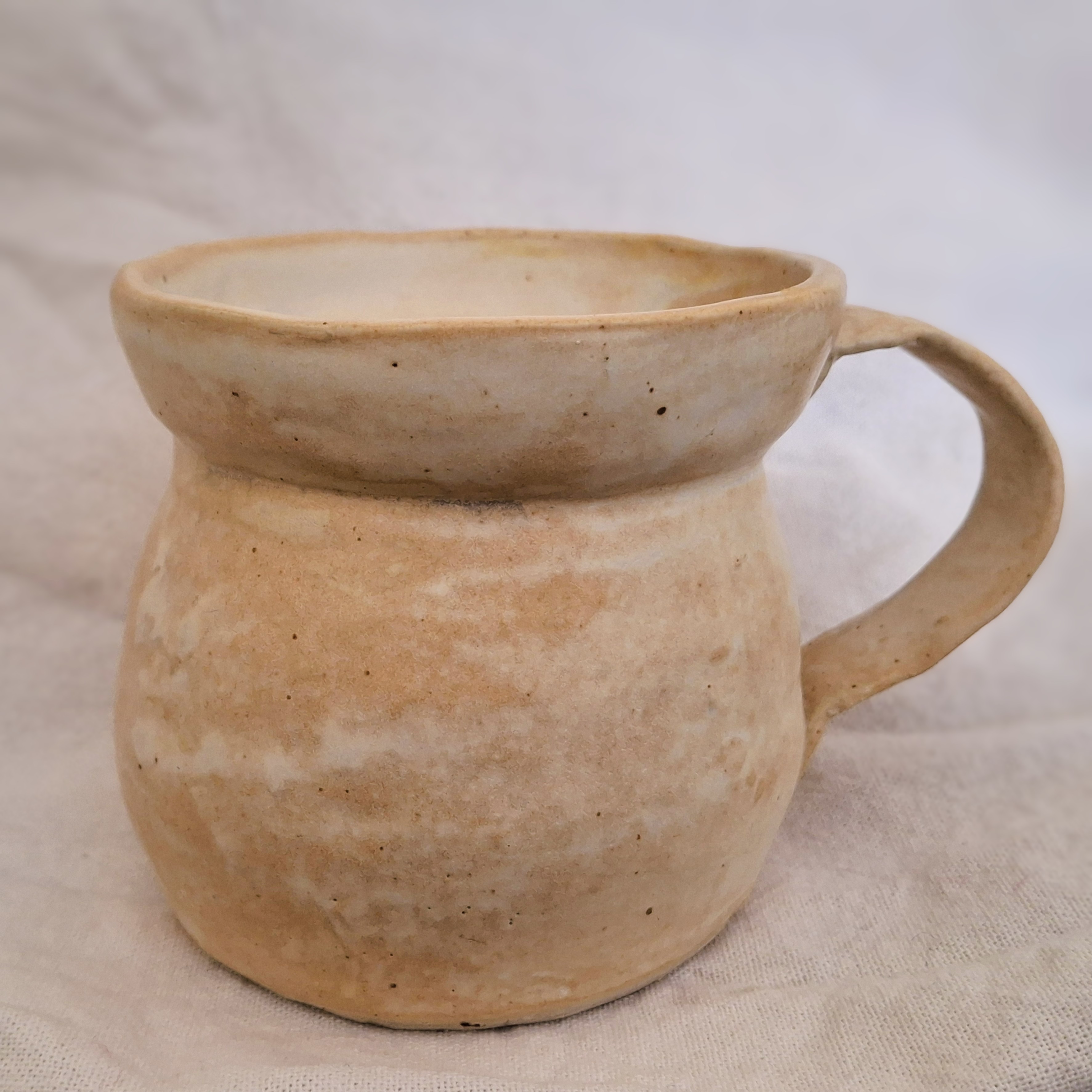A small yellow ceramic mug